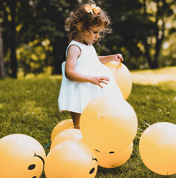 bambina con palloncini gialli